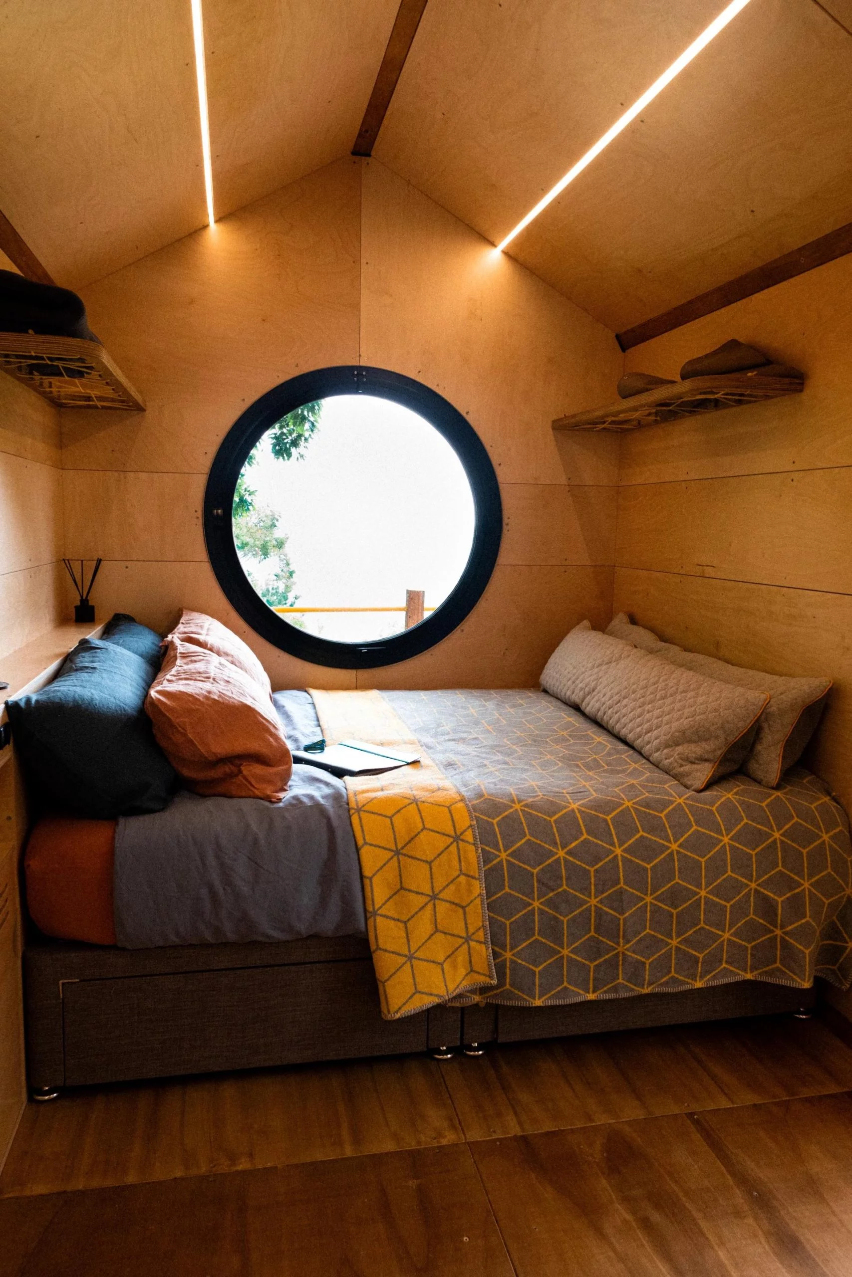 The showcased Birdhouse Modular model includes a bedroom with a circular porthole window and a king-size bed